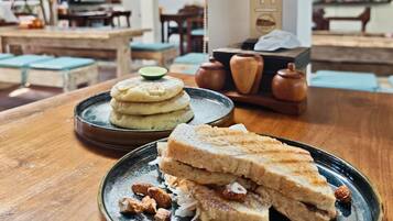 A table with a plate of food, a teapot, and a number 11 sign in a cafe setting.