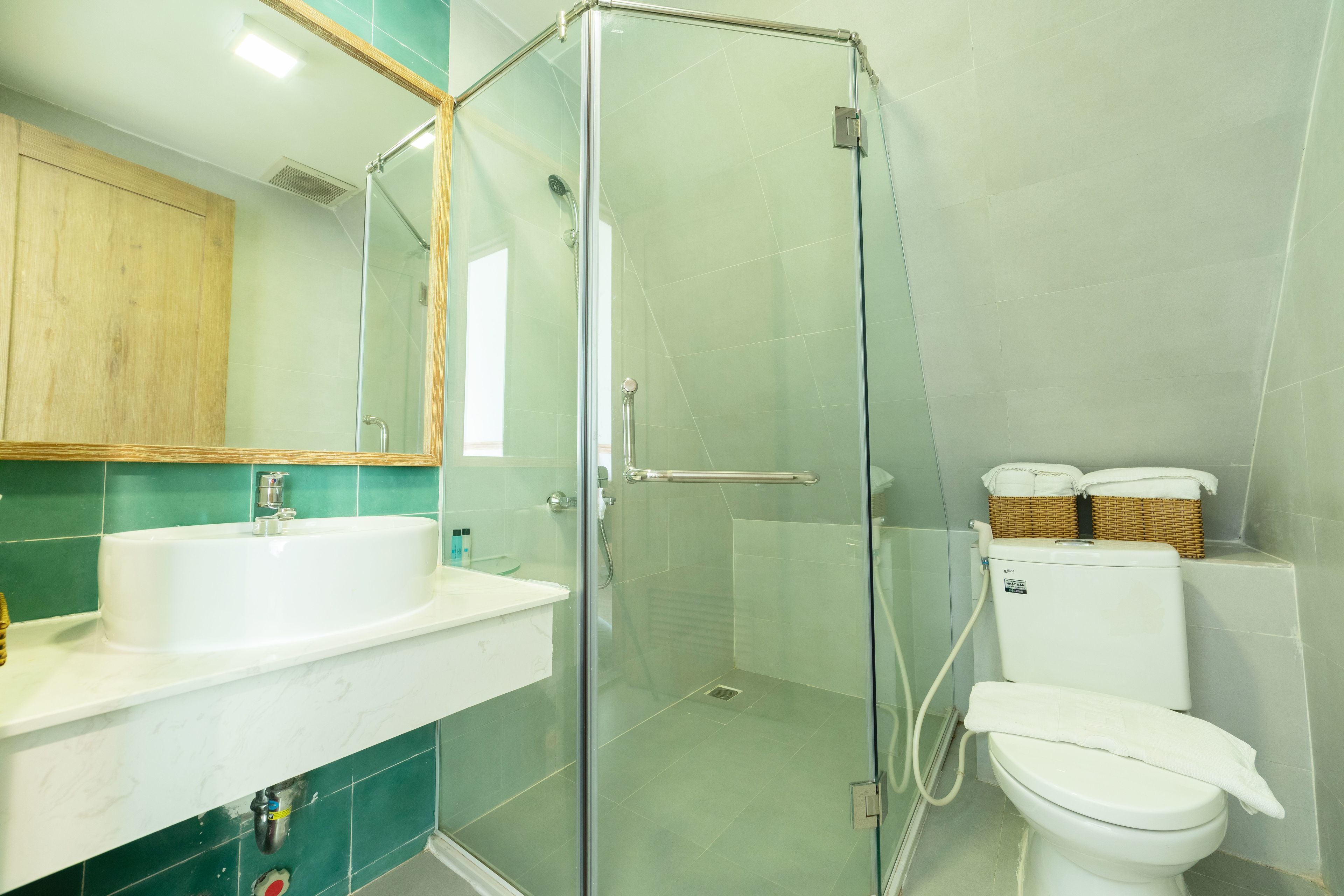 Ein Badezimmer mit Duschkabine, weißem Waschbecken und Toilette.