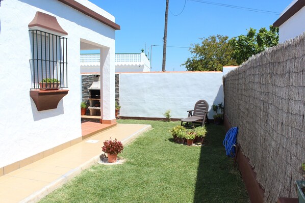 Enjoy a serene outdoor space with a lush lawn and a potted plant on the balcony.