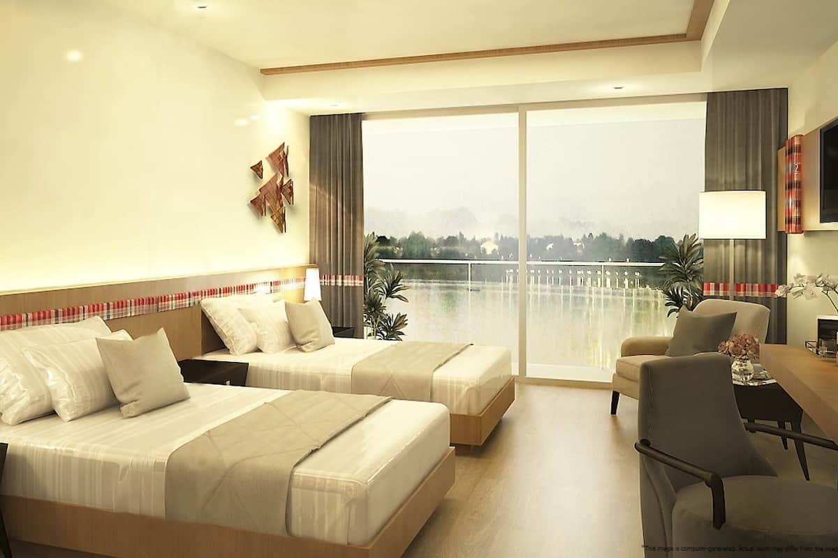 Habitación de hotel con dos camas, un escritorio, una silla, un televisor y un ventanal con vistas.