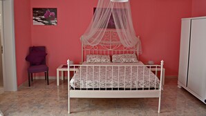 A bedroom with a bed, a chair, and a cabinet. - PINK BAY HOUSE 100 MT FROM THE SEA  (Marina San Gregorio)