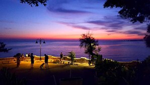 A sunset view with a beach, people, and a dog. - PINK BAY HOUSE 100 MT FROM THE SEA  (Marina San Gregorio)