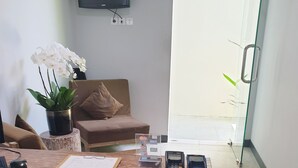 Una mesa de madera con un portapapeles, una orquídea en maceta, un teléfono inteligente y un terminal de pago.