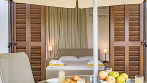 A room with a bed, a table with breakfast items, and a view of the bed through wooden shutters. - Four Bedroom Front Line (Sea-Front) villa located in an excellent location in the area of Cape Greco (Protaras)