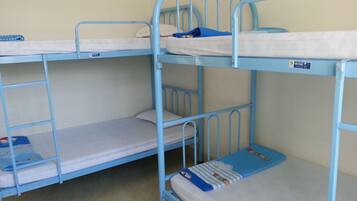 A bunk bed room with a blue metal frame, white bedding, and a blue blanket on the lower bunk.