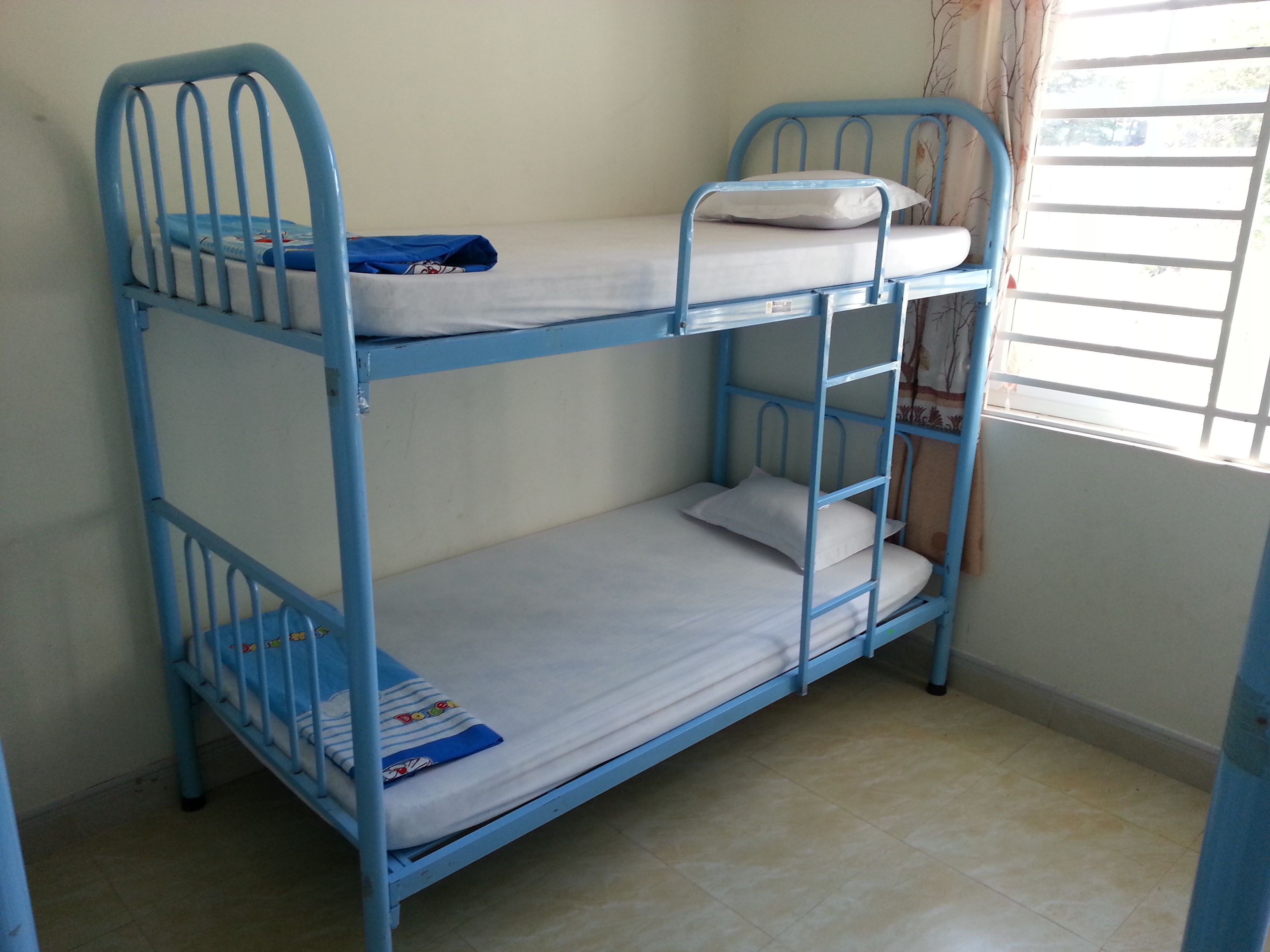 A bunk bed with two levels, each with a mattress and pillows.