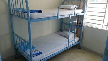 A bunk bed with two levels, each with a mattress and pillows.