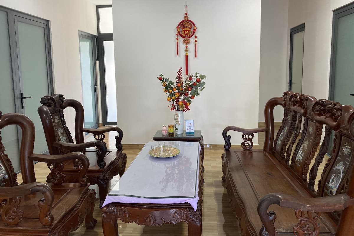 Comedor de madera tradicional con sillas ornamentadas y una mesa central, con un adorno colgante decorativo.