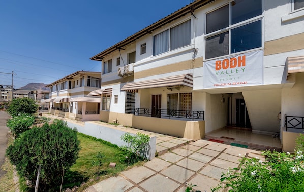 A row of two-story buildings with a sign for Bodh Valley Resort, indicating premium rooms.
