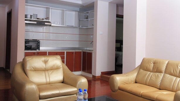 A living room with two leather sofas and a glass coffee table. - YINM Luxury Apartment (Addis Ababa)