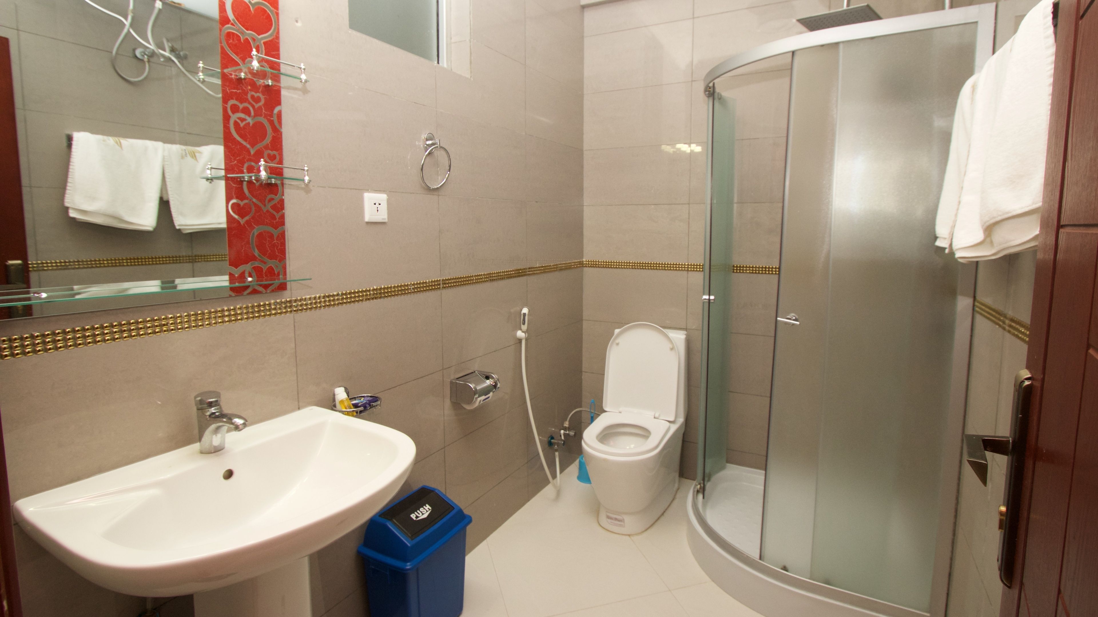 A bathroom with a glass-enclosed shower, a sink, and a toilet.