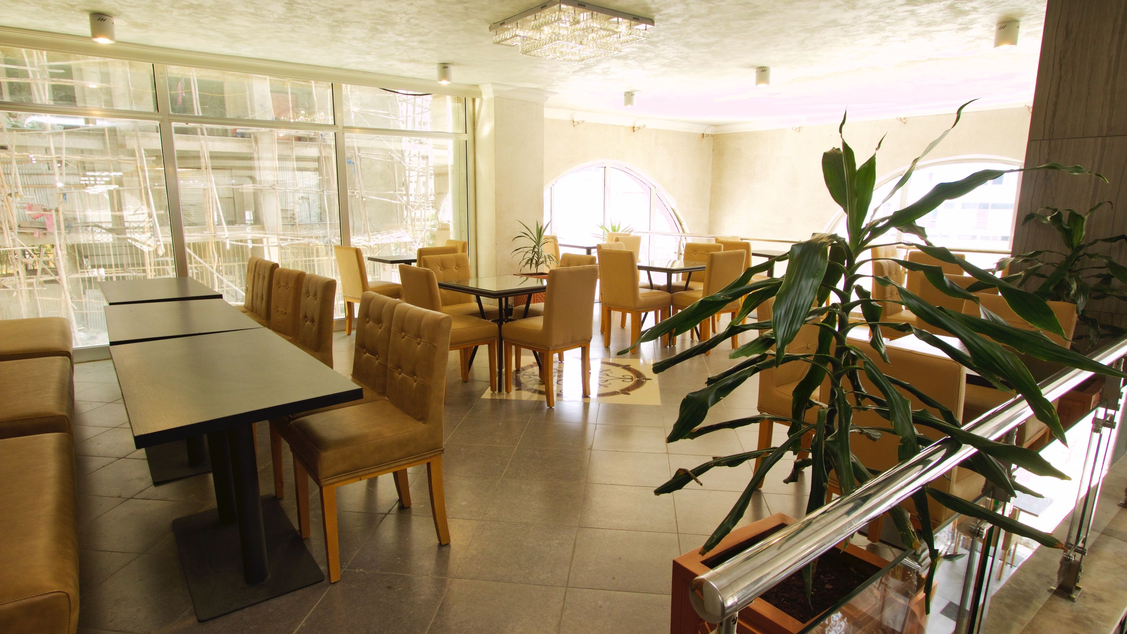 A spacious dining area with high ceilings, large windows, and comfortable seating.