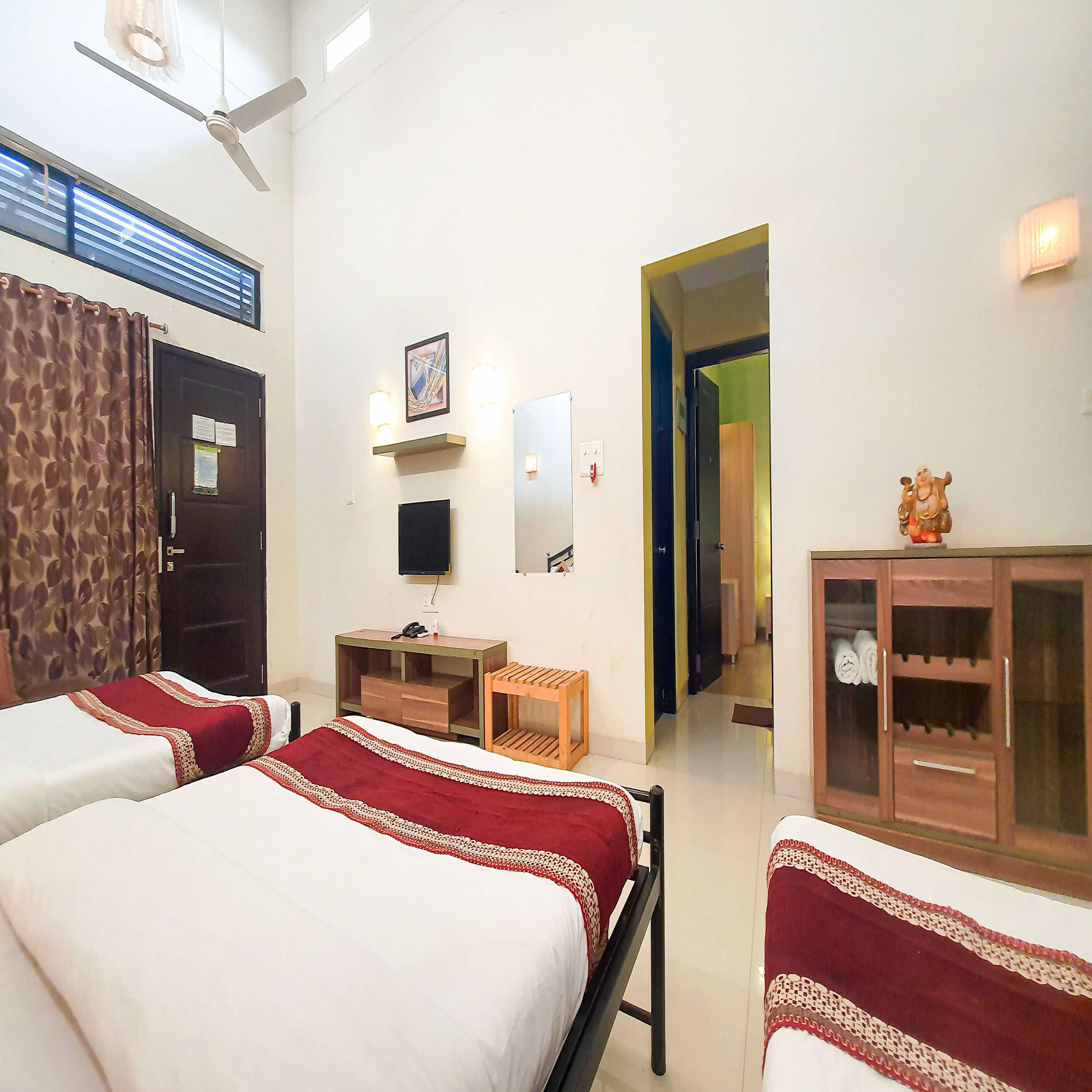 Une chambre d’hôtel avec deux lits, un bureau, une télévision et une armoire.