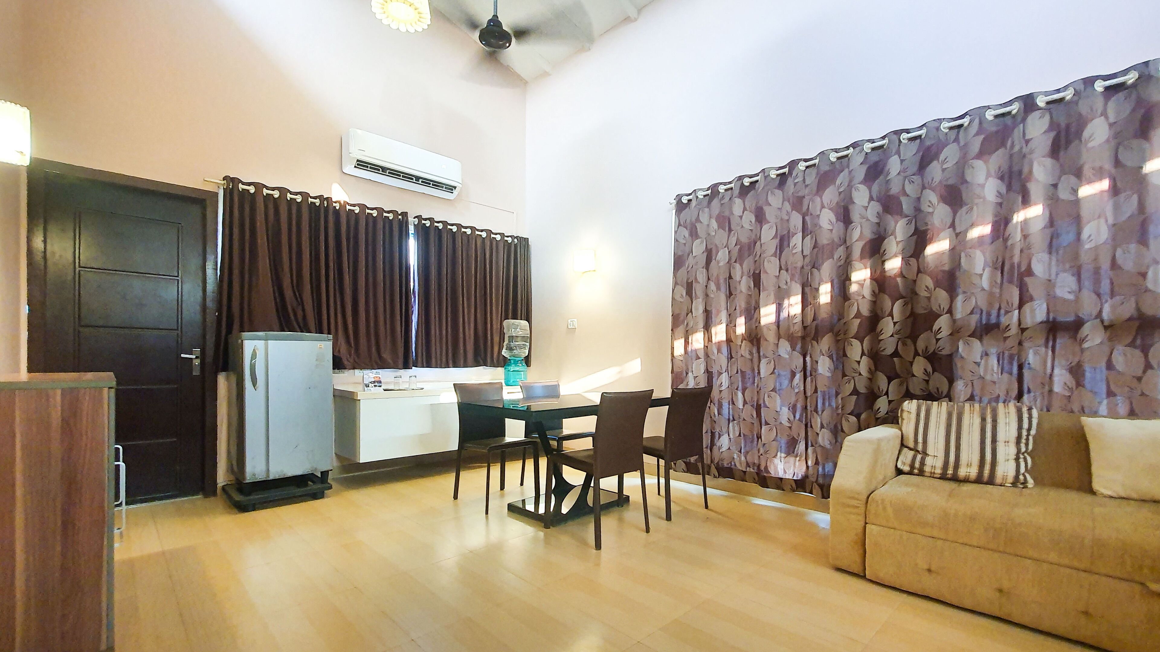 Un espacio habitable compacto con kitchenette, comedor y sofá.