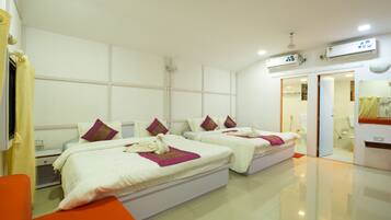 A hotel room with two beds, a bathroom, and a mirror.