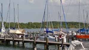 Ein Yachthafen mit mehreren Segelbooten, die an hölzernen Stegen festgemacht sind.