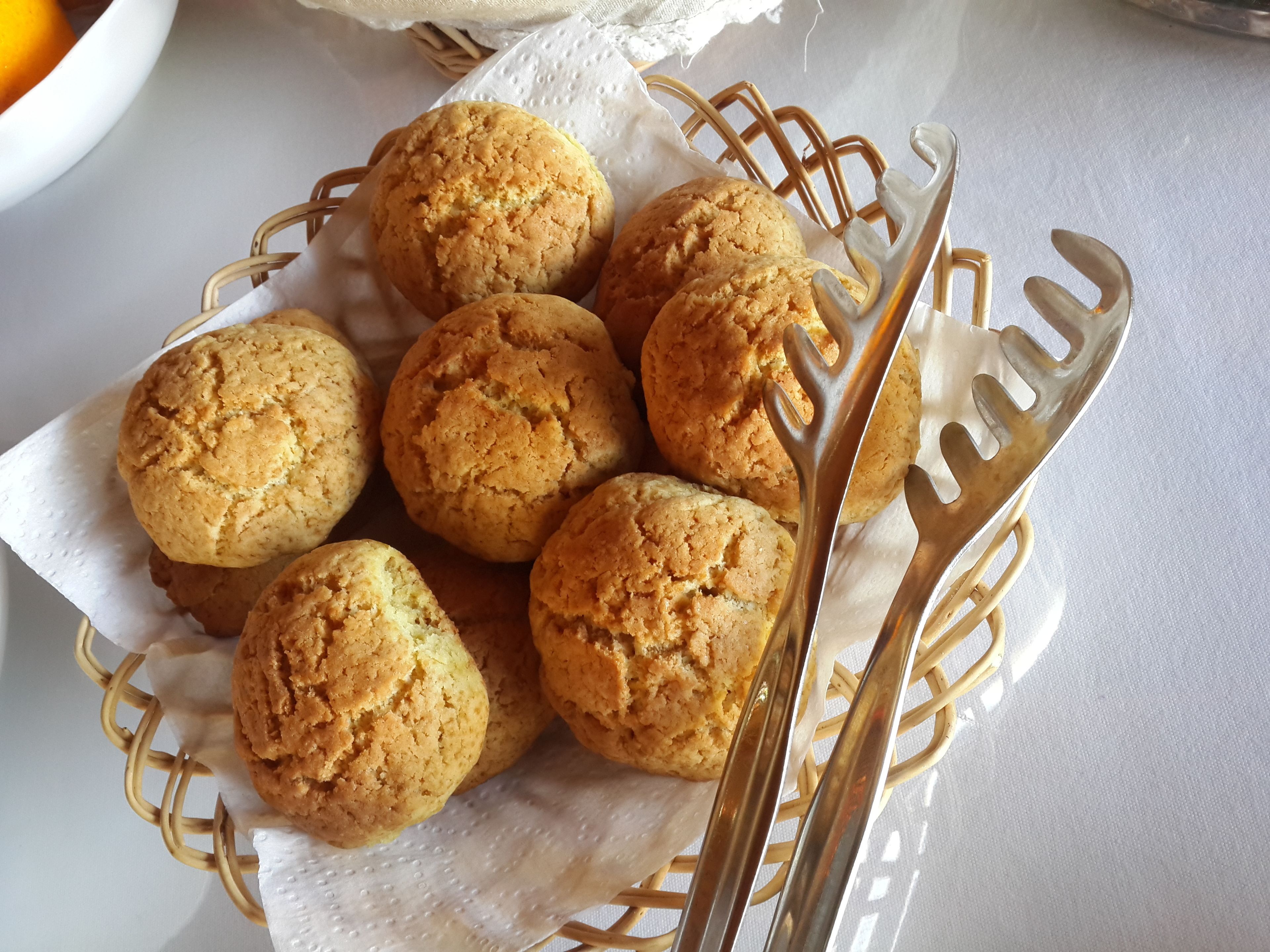 A basket of cookies on a white tablecloth.
