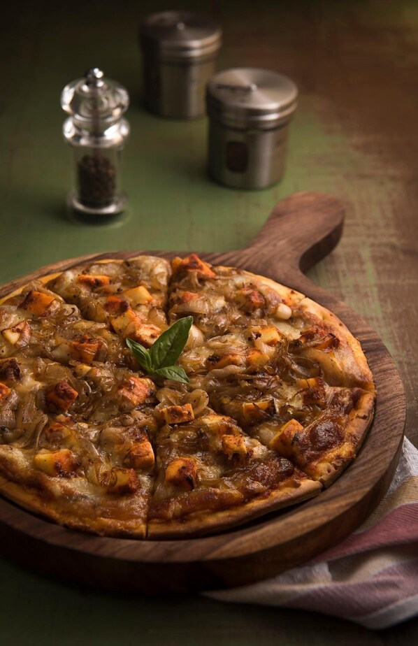 Una pizza sobre una tabla de madera con un fondo rústico.
