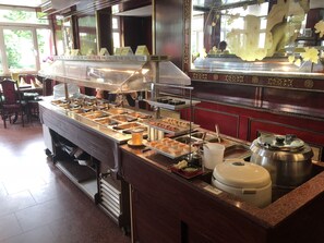 A buffet setup with multiple food stations and a beverage dispenser. - Simona Hotel Frankfurt Airport (Hofheim am Taunus)