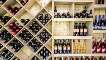 Una bodega con estantes y cavas de madera llenas de diferentes botellas de vino.