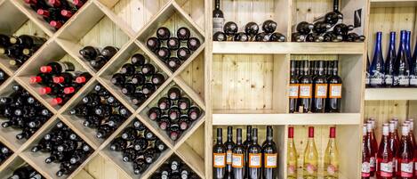 A wine cellar with wooden shelves and racks filled with various wine bottles.