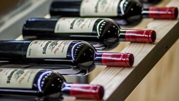 Een rij wijnflessen op een houten plank.