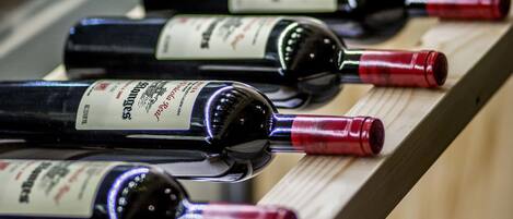 Una fila de botellas de vino sobre un estante de madera.
