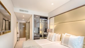 A modern hotel room with a large bed, a walk-in closet, a bathroom with a glass shower, and a large mirror. - MeraPrime Gold Design Hotel (Lisbon)