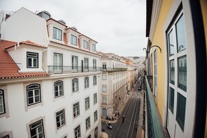 A narrow street lined with multi-story buildings, featuring balconies and large windows.