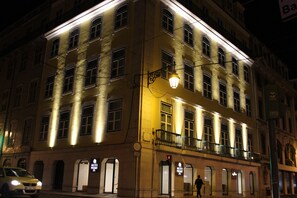 A multi-story building with illuminated windows and a visible entrance. - MeraPrime Gold Design Hotel (Lisbon)