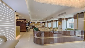 A modern hotel lobby with a reception desk, seating area, and a large chandelier. - MeraPrime Gold Design Hotel (Lisbon)