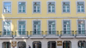 A yellow building with multiple windows and balconies, featuring a sign for 'Mera Prime' and 'Fly & Stay'. - MeraPrime Gold Design Hotel (Lisbon)