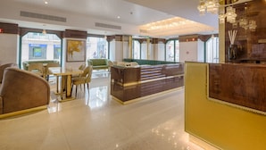 A hotel lobby with a reception desk, seating area, and large windows. - MeraPrime Gold Design Hotel (Lisbon)