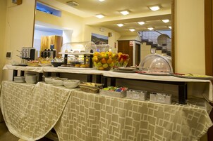 Un buffet allestito con diversi cibi e utensili da portata.
