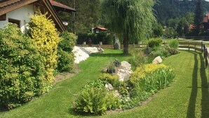A well-maintained garden with a variety of plants and a wooden fence. - (2) FeWo Bergveilchen, Zwei-Raum-Wohnung, ca. 43 qm, mit Terrasse (Reit im Winkl)