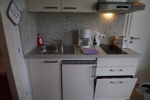 A compact kitchen with a sink, a coffee maker, a toaster, and a microwave. - Apartment Sonntagshorn 36sqm, balcony, 1 bedroom, living room, WLAN, 3 p. (Ruhpolding)