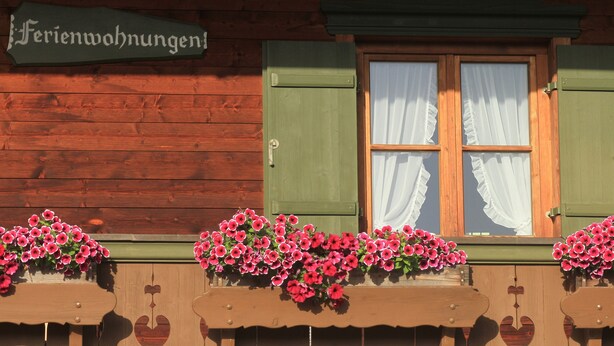 Ein Holzhaus mit einem Schild, auf dem Ferienwohnungen steht.