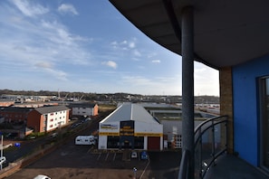 A storage facility with a 'Self Storage' sign, a parking lot, and a view of a town in the background.