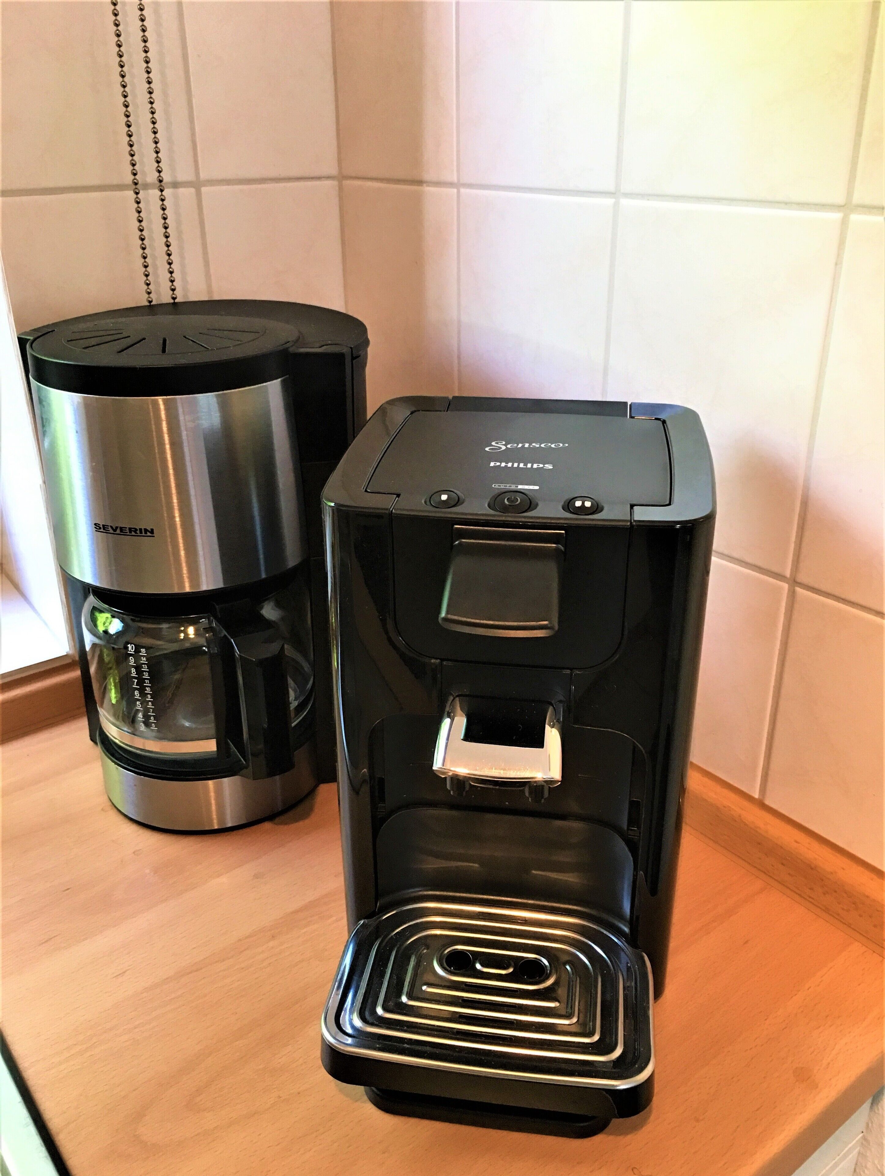 Una cafetera y un dispensador de agua sobre una encimera de cocina.