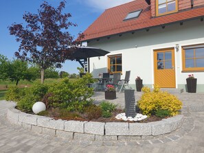 A house with a red-tiled roof, a white exterior, and a wooden door.