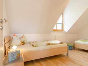 A child's bedroom with a bunk bed, a bedside lamp, and a book on the nightstand. - Apartment with balcony - Panorama Apartments Thiem (Waischenfeld-Siegritzberg)