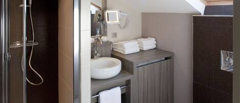 A modern bathroom with a glass-enclosed shower, a sink, and a toilet.