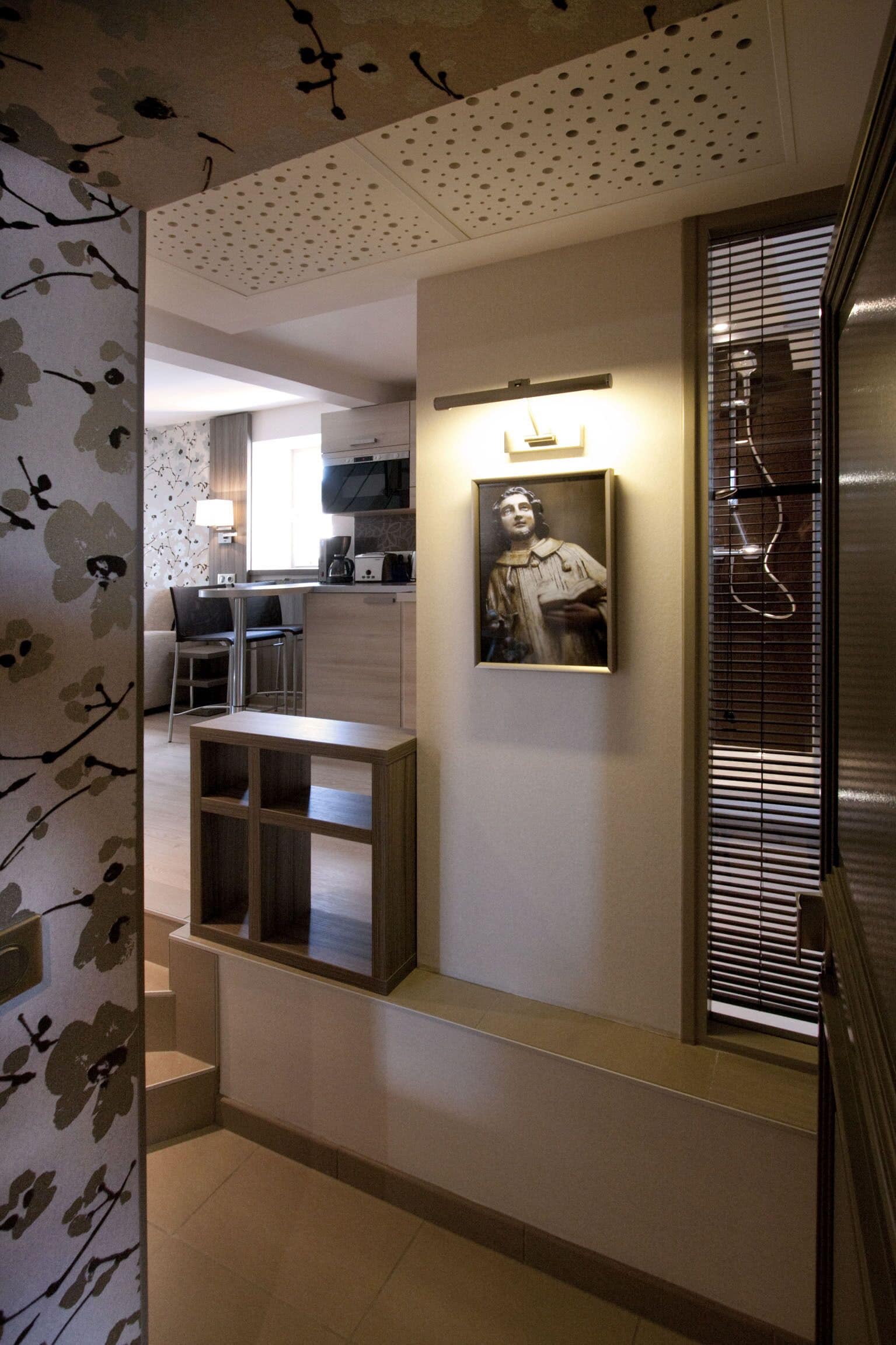 A modern kitchen with a dining area, a framed picture on the wall, and a staircase leading to another level.