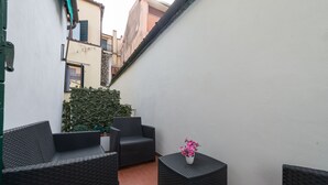 A small outdoor seating area with wicker furniture and a potted plant. - B&B DA NINA VENEZIA  (Venice)
