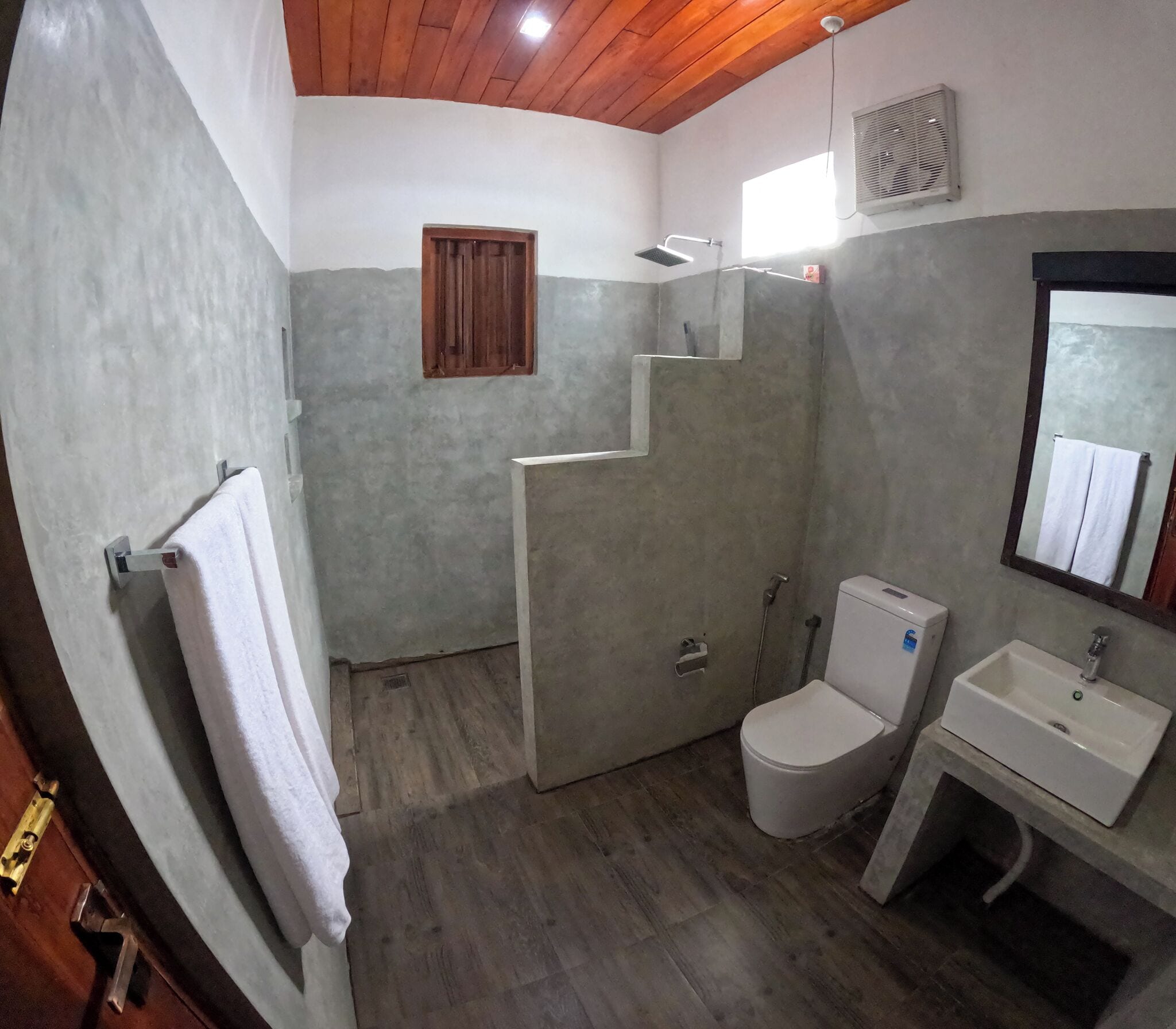 A bathroom with a shower, toilet, and sink.