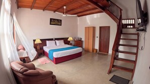A bedroom with a bed, bedside tables, a chair, a wardrobe, and a staircase. - Surf Bay Villa (Dikwella)