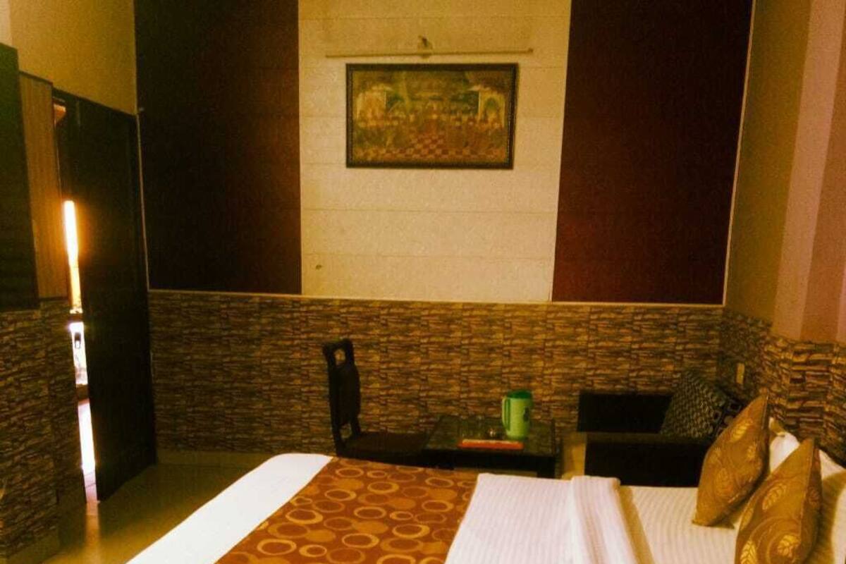 A hotel room with a bed, a small table, and a chair.