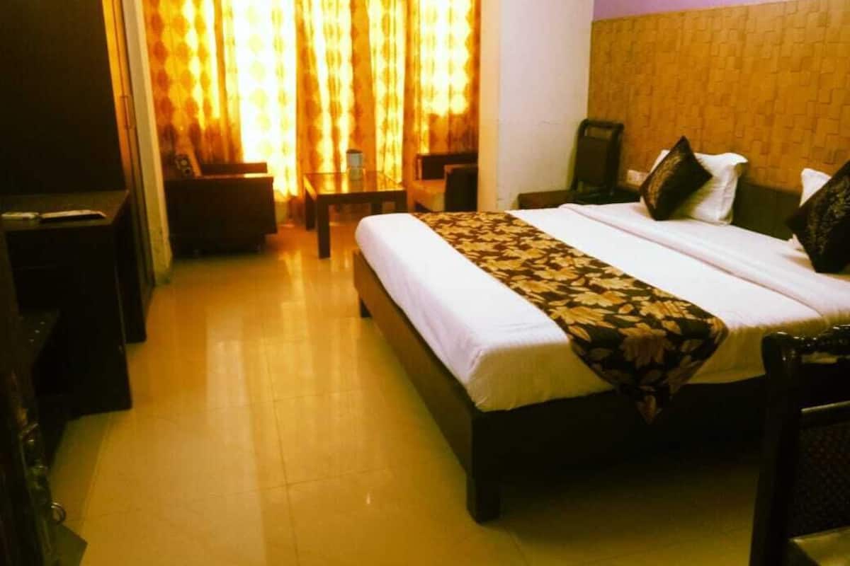 A hotel room with a bed, a desk, and a chair.