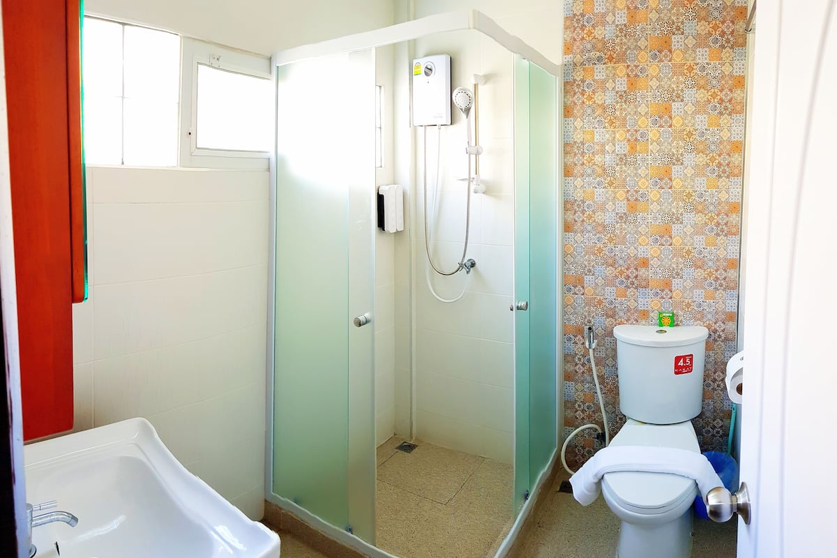 A bathroom with a shower, toilet, and sink.