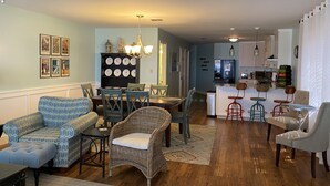 A spacious living room with a dining area, kitchen, and a small bar area. - 213 Seashack- Your Dream Beach Retreat, Steps from the Shore (St Joe Beach)
